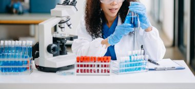 Modern tıbbi araştırma laboratuvarı. Kadın bilim adamı mikro pipetlerle çalışıyor biyokimyasal örnekleri analiz ediyor, tıp için ileri bilim kimya laboratuvarı.