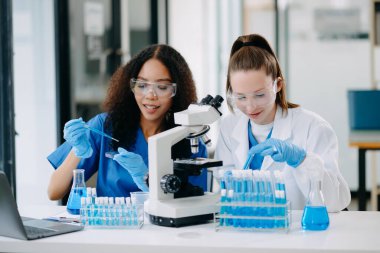 Laboratuvarda online okuma, test örnekleri ve yenilikler ile tıbbi görüşme yapan iki bilim adamı veya tıbbi teknisyen