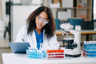 Modern tıbbi araştırma laboratuvarı. Kadın bilim adamı mikro pipetlerle çalışıyor biyokimyasal örnekleri analiz ediyor, tıp için ileri bilim kimya laboratuvarı.