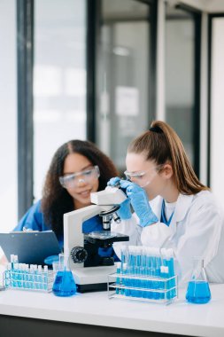 Laboratuvarda online okuma, test örnekleri ve yenilikler ile tıbbi görüşme yapan iki bilim adamı veya tıbbi teknisyen