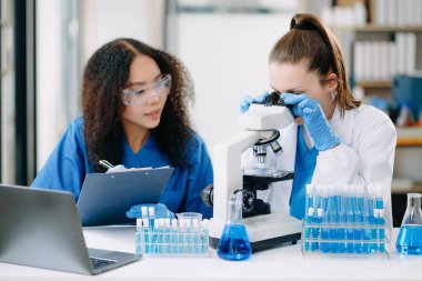 Laboratuvarda online okuma, test örnekleri ve yenilikler ile tıbbi görüşme yapan iki bilim adamı veya tıbbi teknisyen