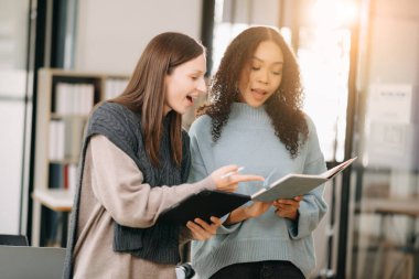 Ofiste konuşan ve tablet kullanan iki iş adamı.