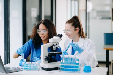 Laboratuvarda online okuma, test örnekleri ve yenilikler ile tıbbi görüşme yapan iki bilim adamı veya tıbbi teknisyen