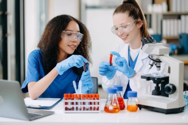 Laboratuvarda online okuma, test örnekleri ve yenilikler ile tıbbi görüşme yapan iki bilim adamı veya tıbbi teknisyen