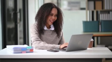 Ofiste dizüstü bilgisayarla çalışan mutlu Afrikalı iş kadını.