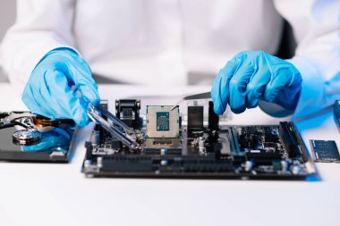 Teknisyen laboratuardaki ana kartı fotokopi aletiyle onarıyor. bilgisayar donanımı konsepti, elektronik, onarım, mavi efekt