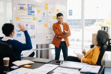 Asyalı iş adamları modern ofiste çalışma sürecini tartışıyor