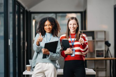 İş kadınları ofiste baş parmak gösteriyor.