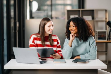 İş kadınlarının lider takımı, birlikte çalıştığı ofiste dizüstü bilgisayar ve dijital tablet kullanıyor.