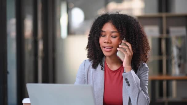 Bilgisayarla Çalışan Ofiste Cep Telefonuyla Konuşan Mutlu Afrikalı Kadını — Stok video