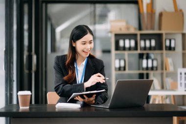 Ofiste çalışmak için dizüstü bilgisayar kullanan kendine güvenen bir iş kadını. 
