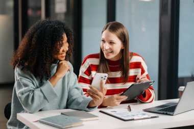 İş kadınlarının lider takımı, birlikte çalıştığı ofiste dizüstü bilgisayar ve dijital tablet kullanıyor.
