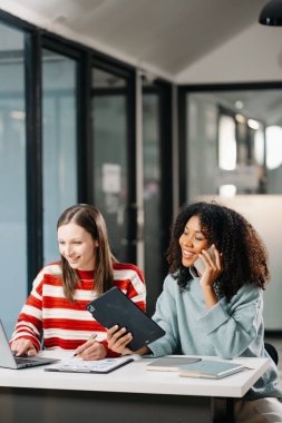 İş kadınlarının lider takımı, birlikte çalıştığı ofiste dizüstü bilgisayar ve dijital tablet kullanıyor.