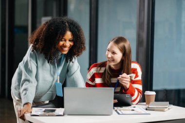 İş kadınları çalışır ve iş planlarını tartışırlar. Afrikalı kadın çalışan, meslektaşına sonuçları açıklıyor ve gösteriyor. 