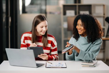 İş kadınlarının lider takımı, birlikte çalıştığı ofiste dizüstü bilgisayar ve dijital tablet kullanıyor.