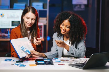  UX geliştiricisi ve ui tasarımcısı modern ofiste müşteri özeti ve renk kodu ile mobil uygulama arayüzü kablo tasarımı hakkında beyin fırtınası yapıyorlar