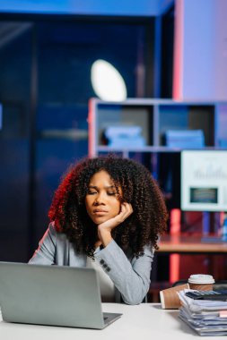 Genç ve güzel bir kadın gece geç saatlere kadar odasında çalışıyor. İş kadını dizüstü bilgisayara bakarken iş yerinin üzerine eğiliyor.