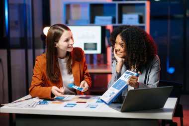  UX geliştiricisi ve ui tasarımcısı modern ofiste müşteri özeti ve renk kodu ile mobil uygulama arayüzü kablo tasarımı hakkında beyin fırtınası yapıyorlar