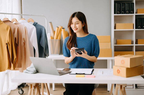 Стартап малого бизнеса МСП, предприниматель владелец женщина с помощью ноутбука принимая и проверяя онлайн покупки заказ на подготовку упаковки продукта коробка.
