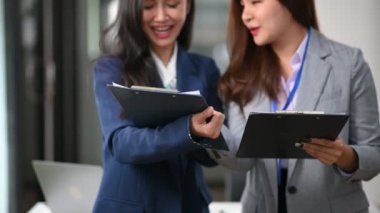 İki Asyalı iş kadını belgelerle birlikte çalışıyor 