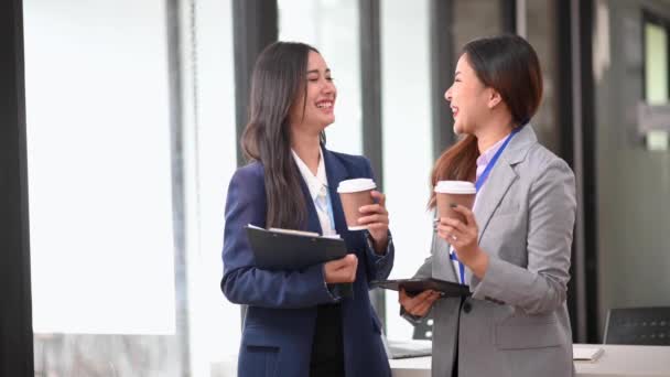 Två Asiatiska Affärskvinnor Chattar Medan Dricker Kaffe Moderna Kontor — Stockvideo