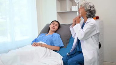  Doktor ve genç kadın hasta, hastane koğuşlarında danışmanlık yaparken yatakta yatıyorlar.