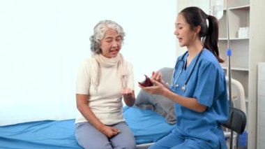 Asyalı doktor hastanedeki yaşlı bir Asyalı kadına ilaç veriyor.
