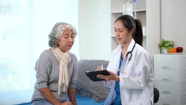 Asiatischer Arzt Macht Sich Notizen Während Asiatische Ältere Patientin Krankenhaus — Stockvideo