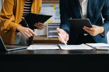 Ofisteki toplantıda dijital tablet ve dizüstü bilgisayar kullanarak mali durumu ve mali görevi analiz eden iş ekibi. Zenginlik yönetimi kavramı