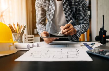 İşadamı elleri, dijital tablet kullanarak, ofis masasında mimarlık projesinde çalışıyor. 