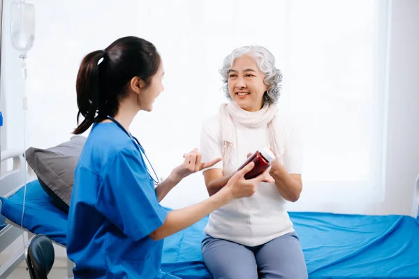 Doctor and Asian elderly woman patient and doctor consult in hospital wards.