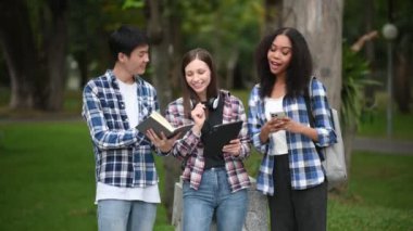 Kampüs parkında birlikte okuyan genç üniversite öğrencileri.