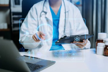 Doktor dijital tablet ve laptop kullanıyor. Sanal ekranlı dijital sağlık hizmeti kavramı, tıbbi teknoloji.