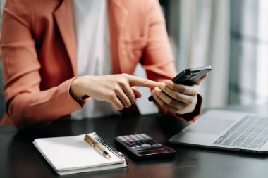 Yeni modern bilgisayarla çalışan ve akıllı telefon kullanan iş kadını. 