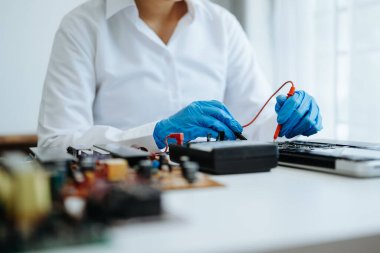 Elektronik teknisyen, elektronik mühendisliği, elektronik onarım, ölçüm ve test, onarım ve bakım kavramları. Atölyede kontrol ve yükseltme için voltaj ölçer kullanır 