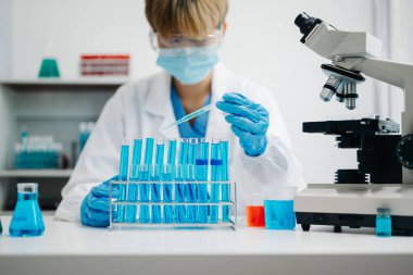 Modern tıbbi araştırma laboratuvarı. Kadın bilim adamı mikro pipetlerle çalışıyor biyokimyasal örnekleri analiz ediyor, tıp için ileri bilim kimya laboratuvarı.