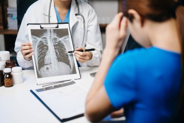  Kadın doktor, röntgen ve dizüstü bilgisayarı olan bir hastaya danışıyor. İlaç ve sağlık hizmetleri kavramı. 