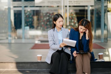 Ofis dışında bir hata yaptıktan sonra iki Asyalı iş kadını şiddetle tartışıyor.