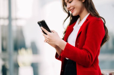 İş kadını bulanık ofis geçmişinde cep telefonu kullanıyor