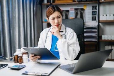 Ofis hastanesindeki masada oturan güzel doktor. İş için dizüstü bilgisayar kullanan çekici bir kadın terapist. 