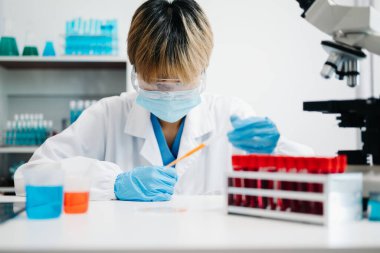 Modern tıbbi araştırma laboratuvarı. Kadın bilim adamı mikro pipetlerle çalışıyor biyokimyasal örnekleri analiz ediyor, tıp için ileri bilim kimya laboratuvarı.