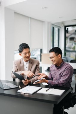 İş adamları hesap makinesi ve tablet bilgisayar kullanarak finansal görevi analiz ediyorlar. Zenginlik yönetimi