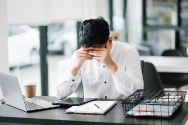 Asyalı işadamı modern ofiste çalışmaktan sıkılmış ve stresli
