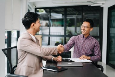 Ofiste tokalaşan iki mutlu iş adamı. Başarılı bir anlaşma.