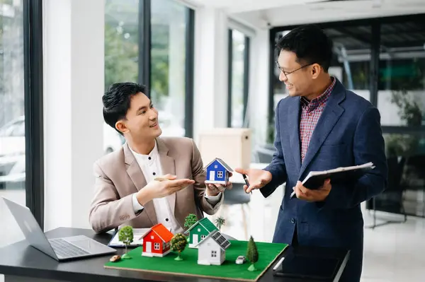 Salesman and customer Hands On House Model , Small Toy House Small Mortgage Property insurance and concepts real estate