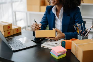 Bilgisayarda düşman görevi yapan genç bir kadın, online alışveriş konsepti olarak ofiste