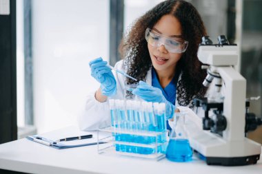 Modern tıbbi araştırma laboratuvarı. Kadın bilim adamı mikro pipetlerle çalışıyor biyokimyasal örnekleri analiz ediyor, tıp için ileri bilim kimya laboratuvarı.