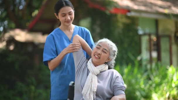 Молодая Азиатская Женщина Врач Делает Физиотерапию Пожилой Женщине Инвалидной Коляске — стоковое видео