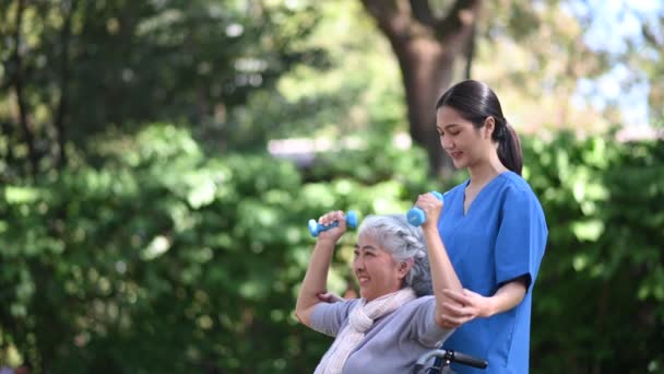 Молодая Азиатка Врач Помогает Пожилой Женщине Инвалидной Коляске Заниматься Физкультурой — стоковое видео
