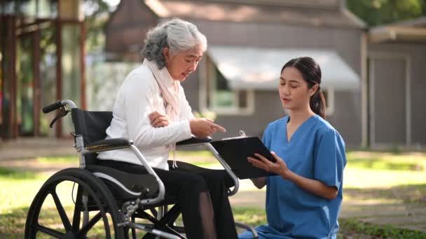 Азиатский Врач Делает Заметки Время Осмотра Азиатской Пожилой Пациентки Инвалидной — стоковое видео